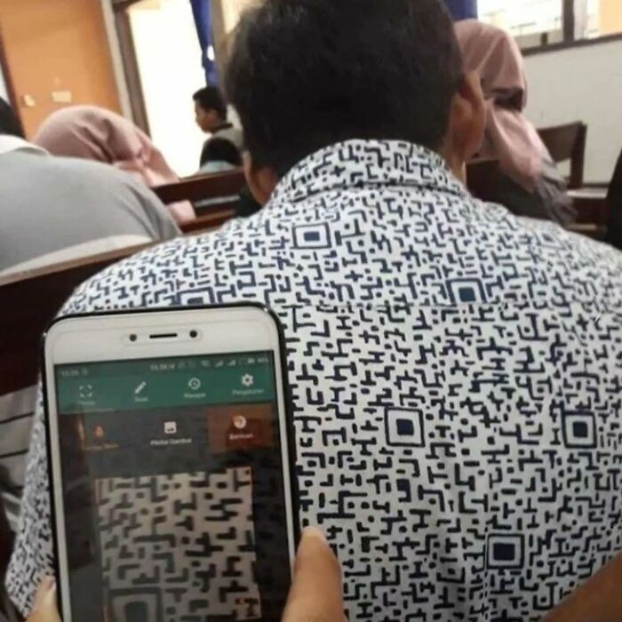 A person scanning a QR code pattern on another person's shirt, an example of cringe posts.