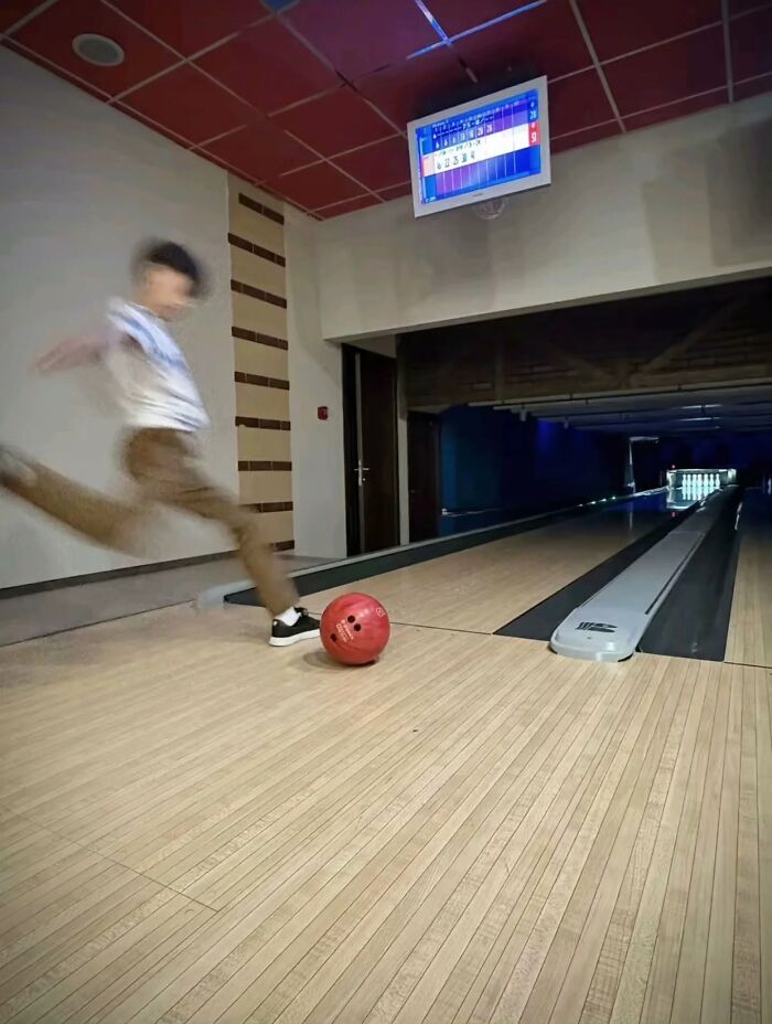 A blurred person kicking a bowling ball down an alley, a funny yet cringe post about bowling.