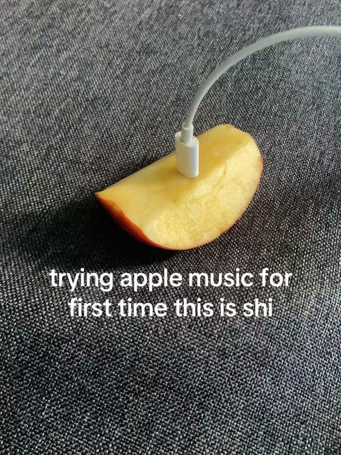 An Apple charger plugged into an apple slice, a cringe post about Apple Music.