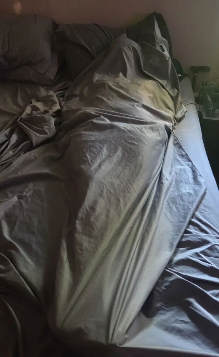 A camera roll photo of a lump under a duvet in a bed, requiring no explanation.