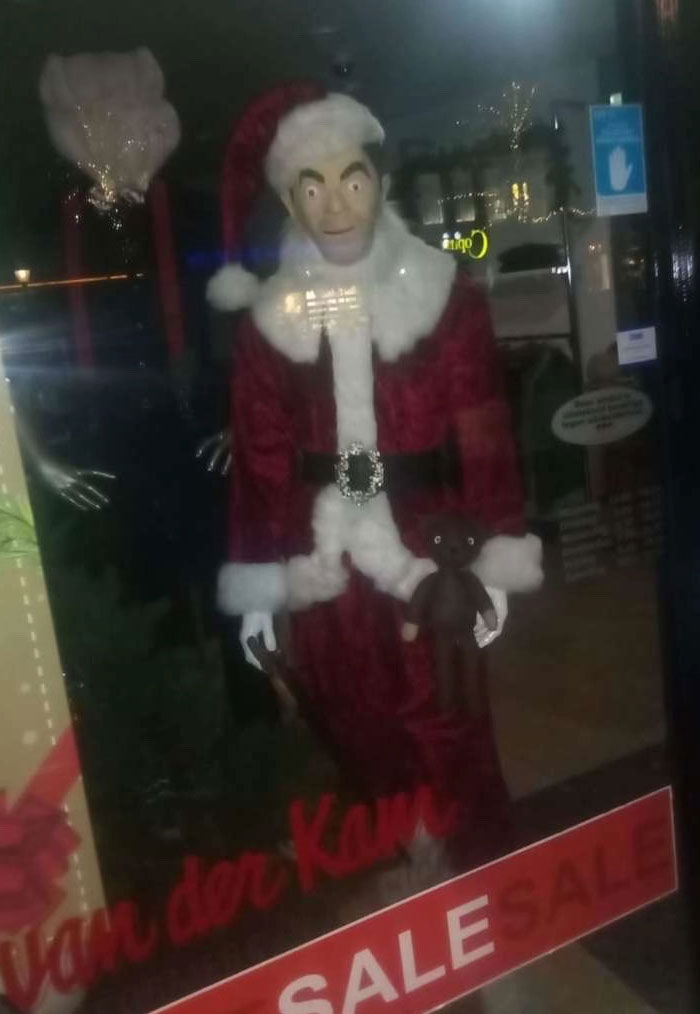 A store display with a Santa Claus mannequin holding a teddy bear, one of 65 camera roll photos.