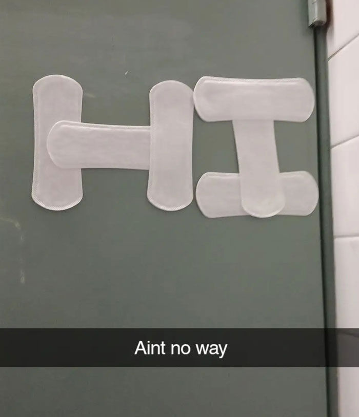 The word HI spelled out with sanitary pads on a gray wall, a strange sight from camera roll photos.