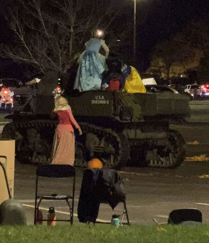 Disney princesses on top of a military tank at night, an unexpected sight among camera roll photos.