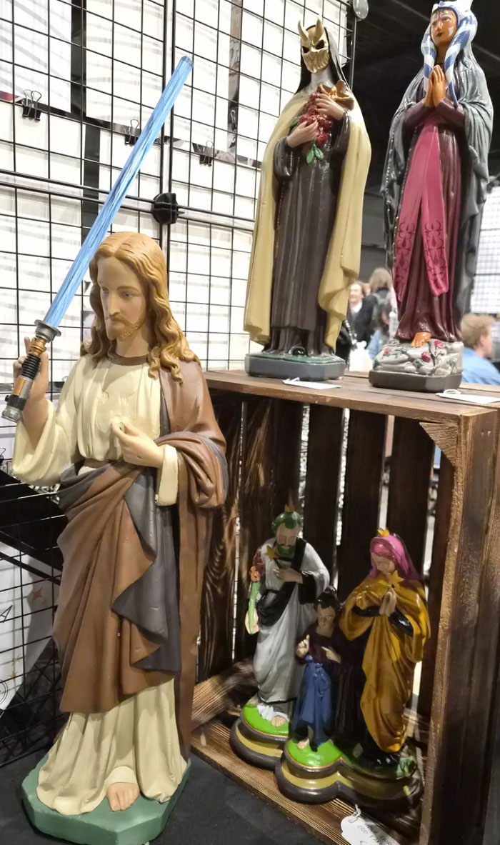 Camera roll photos of various statues, including a Jesus figure holding a blue lightsaber, displayed next to other religious and themed figures.