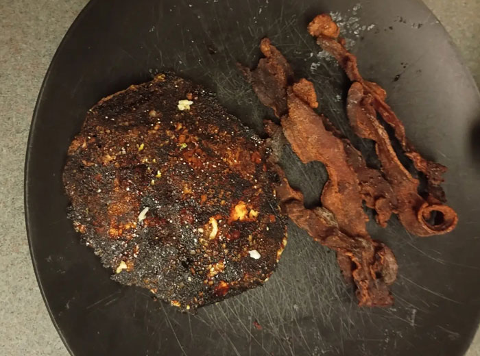 Camera roll photos showing burnt food items, a dark, crispy patty next to several pieces of overcooked bacon.