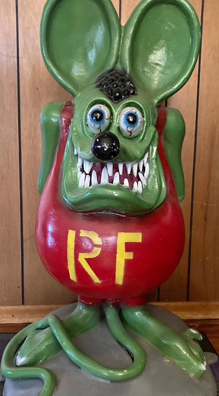 A green monster statue with big ears, red shirt with yellow RF, and sharp teeth from camera roll photos.