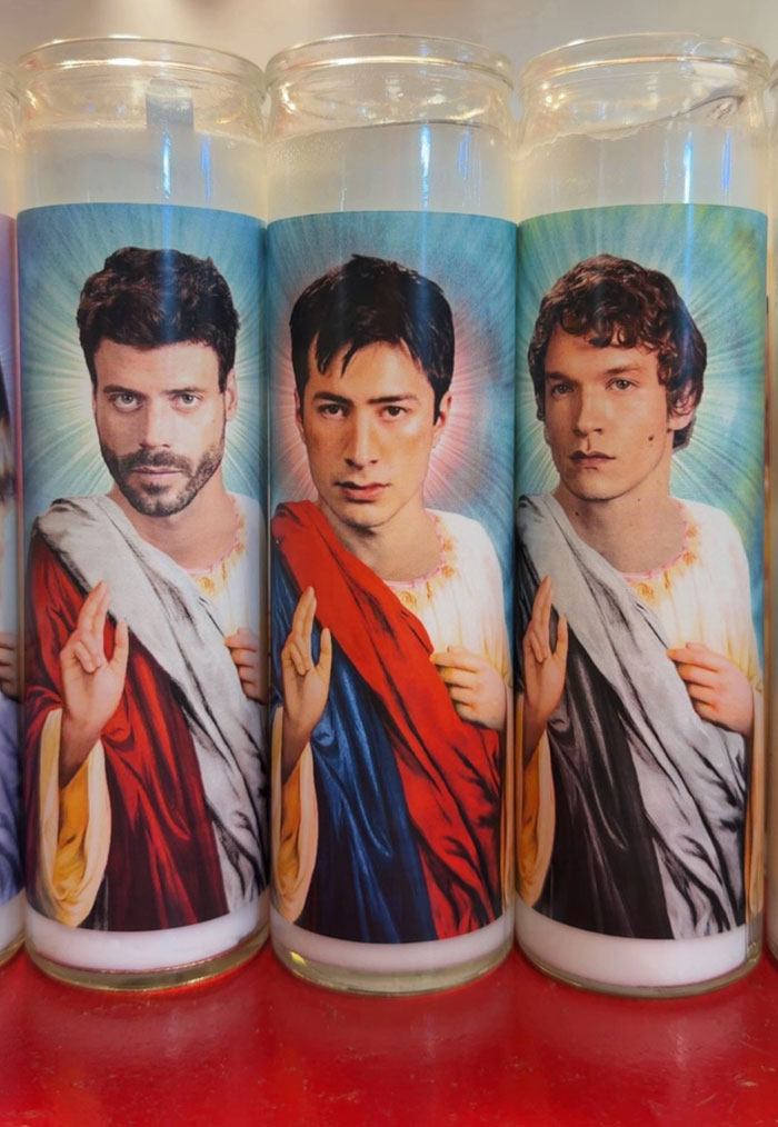 Three candles featuring camera roll photos of men in saint-like robes, needing explanation.