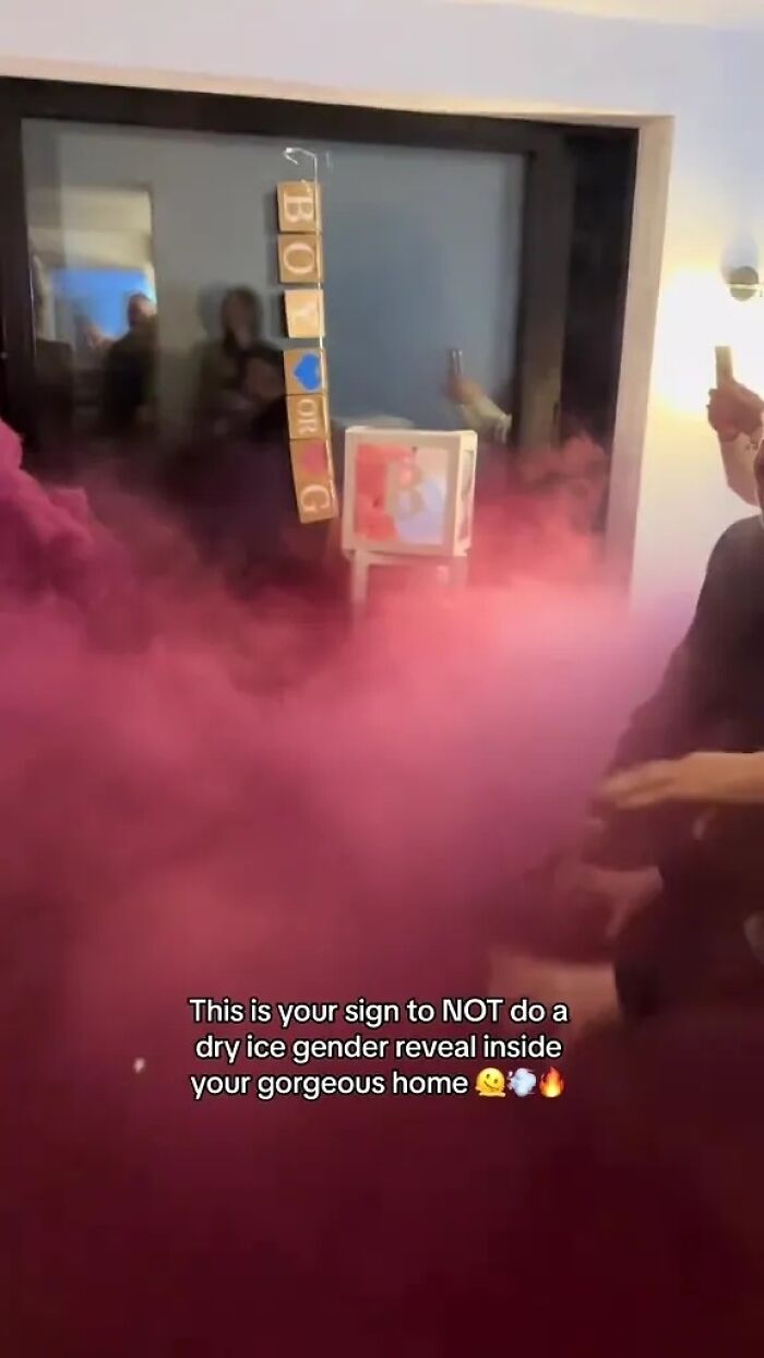 Dense pink smoke filling a room from a dry ice gender reveal, with people reacting to the reveal.