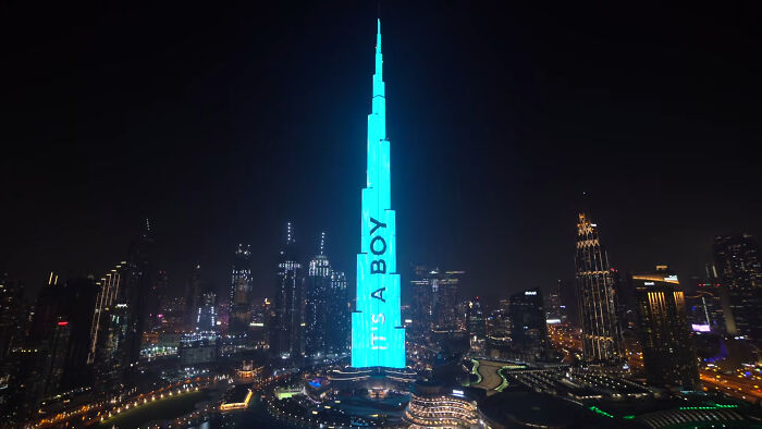 The Burj Khalifa lit up in blue with 'IT'S A BOY' projected, a massive gender reveal moment in Dubai.