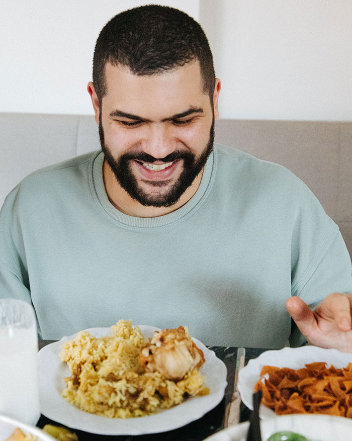 A man happily eating a meal, symbolizing shared culinary experiences that define intercultural relationships.