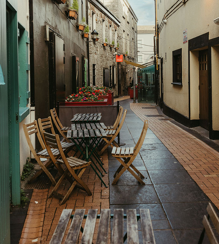 A charming European alley with outdoor seating, representing new environments that can cause culture shocks and impact intercultural relationships.