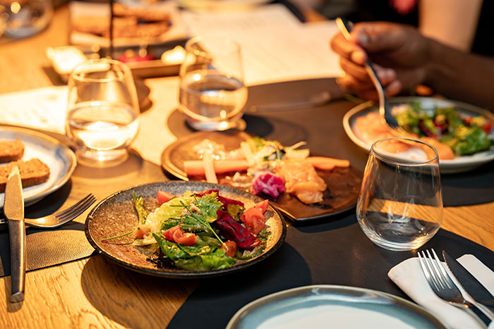 People enjoying a meal at a table with various dishes, representing shared experiences in intercultural relationships.