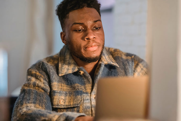 Man focused on his laptop, experiencing a culture shock in intercultural relationships.