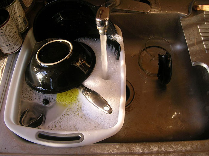 A sink full of soapy dishes, illustrating a common domestic activity that can highlight intercultural relationships.