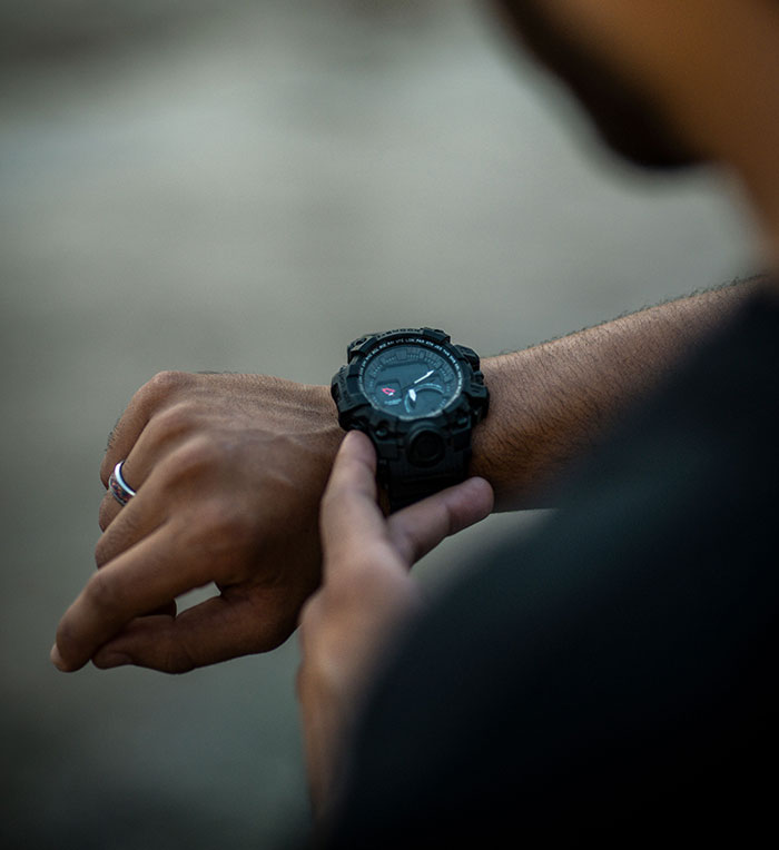 Person checking a watch, signifying the time and patience required for intercultural relationships and culture shocks.
