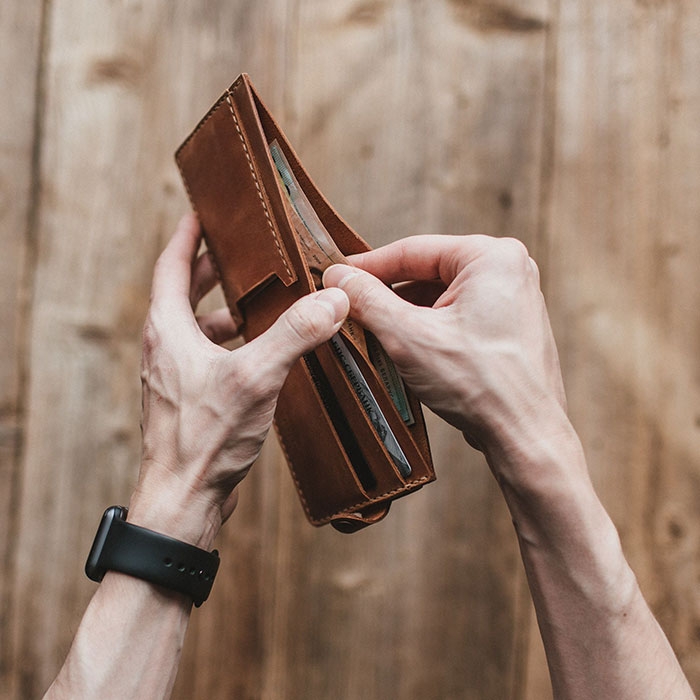 Hands holding a wallet with money, representing financial aspects of culture shocks in intercultural relationships.