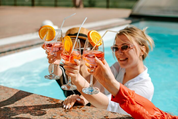 Travelers enjoying drinks by the pool, perhaps adapting to new culture shock experiences.