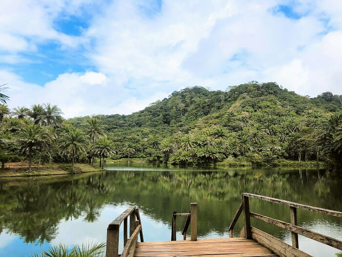 A serene lake and lush green hills, a sight for travelers experiencing culture shock.
