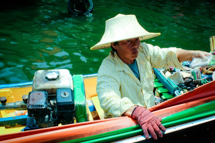 A traveler in a hat on a boat facing culture shock.