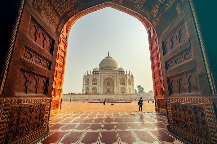 The Taj Mahal framed by an ornate archway, a breathtaking view for travelers experiencing culture shock.