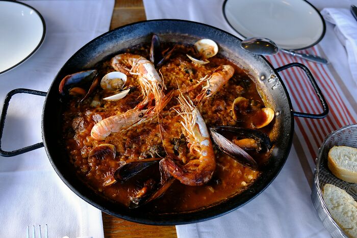 A delicious paella with seafood, representing a culinary experience that might cause culture shock for travelers.