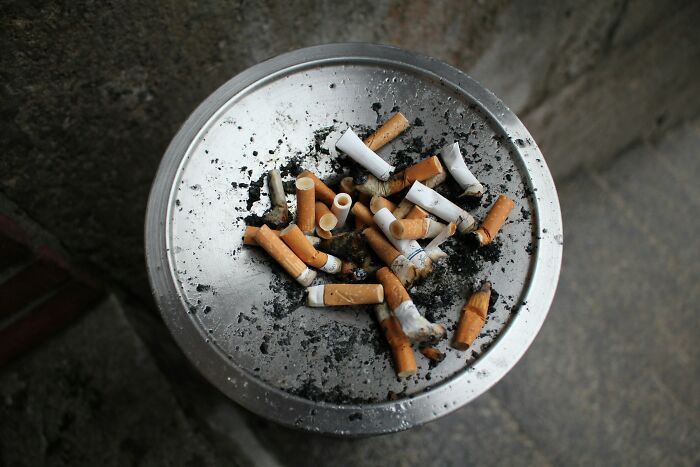 Travelers experiencing culture shock; an ashtray filled with numerous cigarette butts, indicating a common local habit.