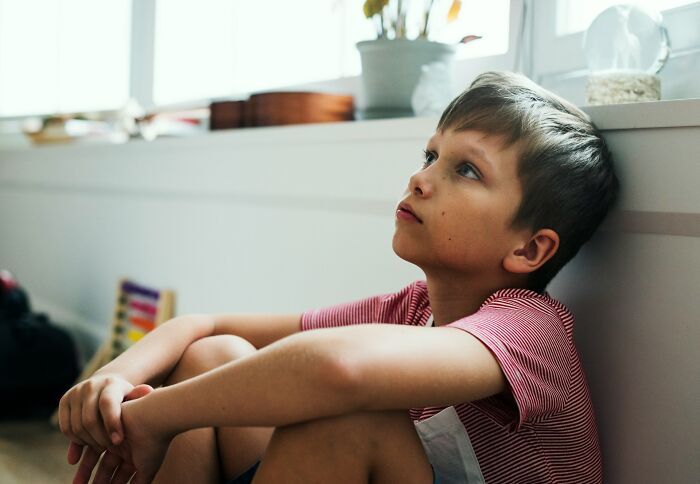 Young boy sits contemplatively, dealing with unhinged therapist moments and emotional recovery.