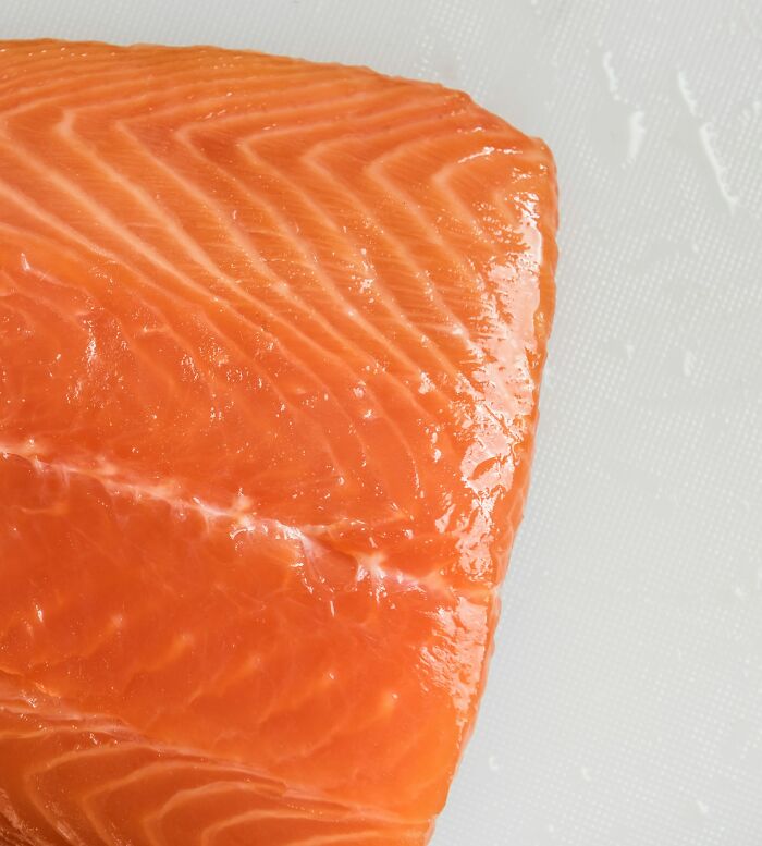 A close-up of a raw salmon fillet, representing varied culinary culture shocks experienced by international partners.
