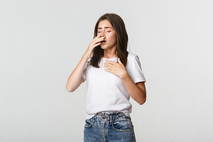 A woman pinches her nose with a look of disgust, representing facts people wish they could forget.