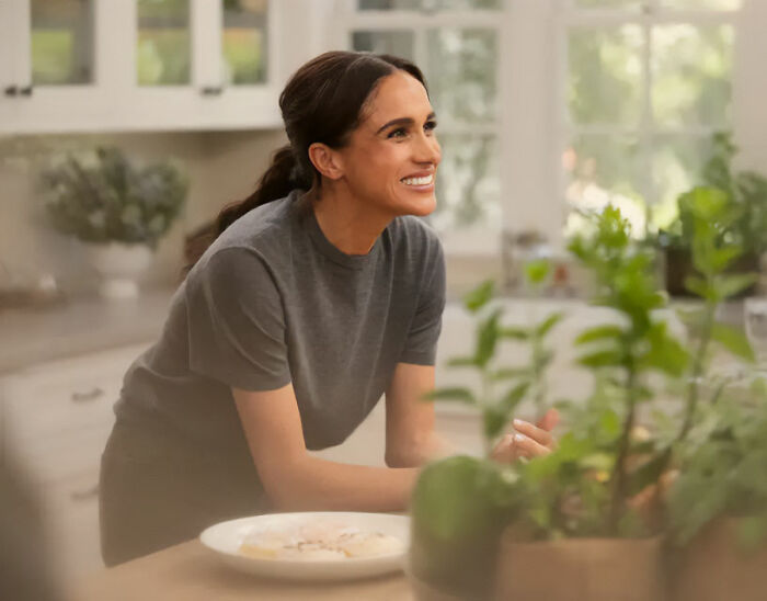 Meghan Markle smiling in a kitchen, amidst ongoing discussions about alleged lies regarding her upbringing. Meghan Markle smiling in a kitchen, amidst ongoing discussions about alleged lies regarding her upbringing.