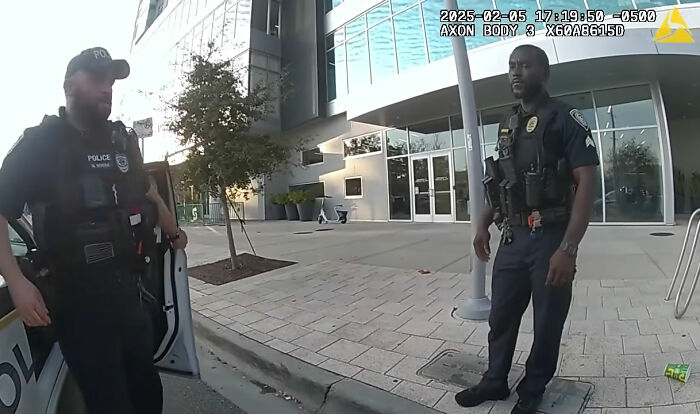 Two police officers are standing by a patrol car, involved in the Trans Florida student arrest. Two police officers are standing by a patrol car, involved in the Trans Florida student arrest.