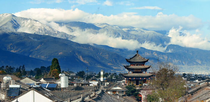 A traditional pagoda in a valley with snow-capped mountains, representing the diverse backdrops of World War II veterans' stories.