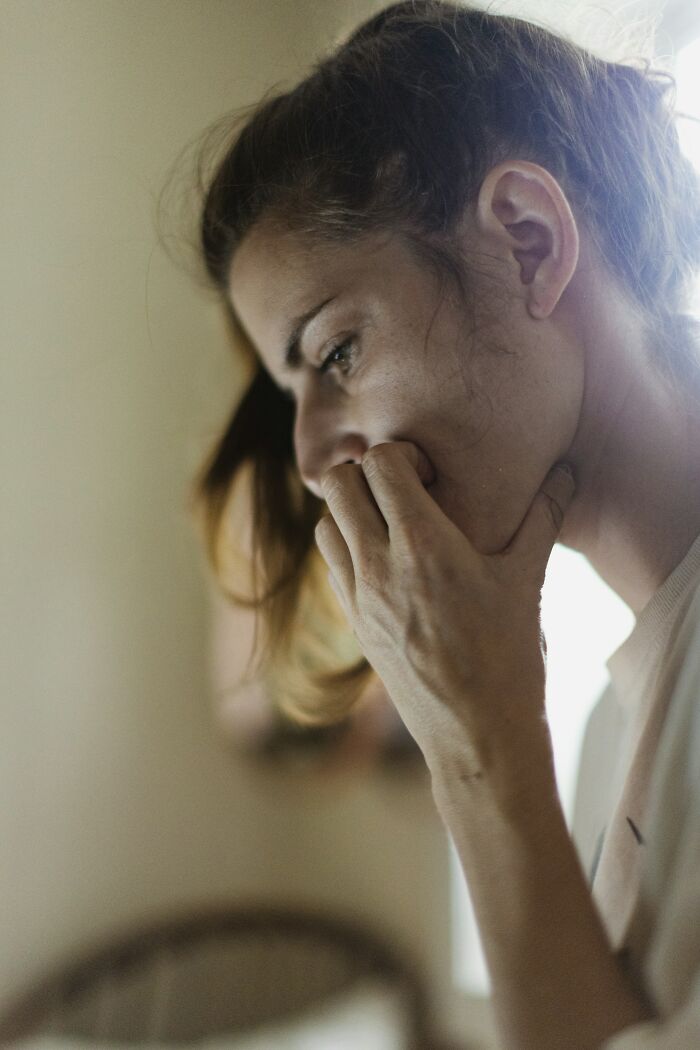 A woman with brown hair looking down, with a concerned expression, illustrating the shocking and unusual ways people have lost their lives.