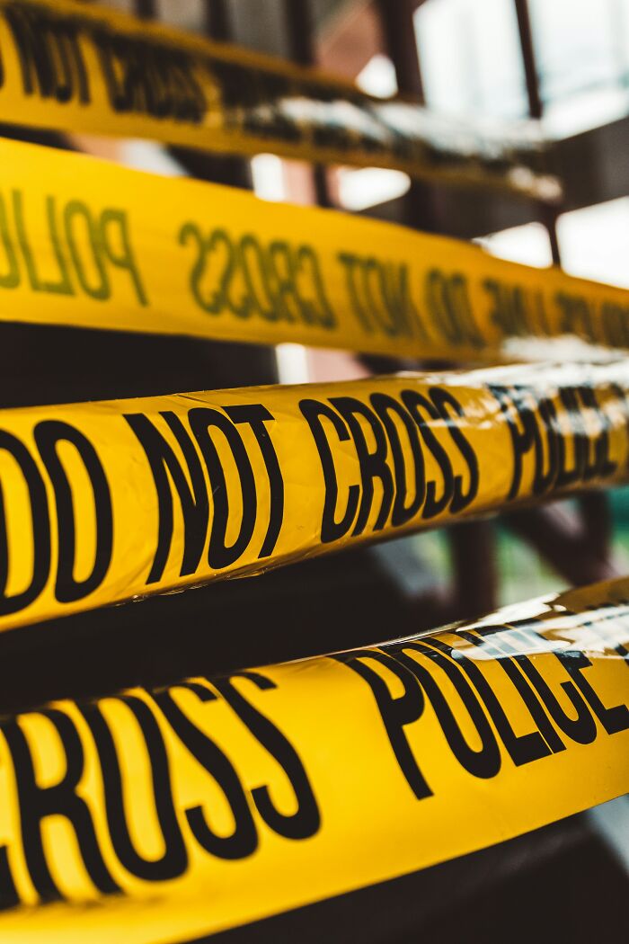 Yellow police tape with DO NOT CROSS written on it, representing a scary, disturbing public scene.