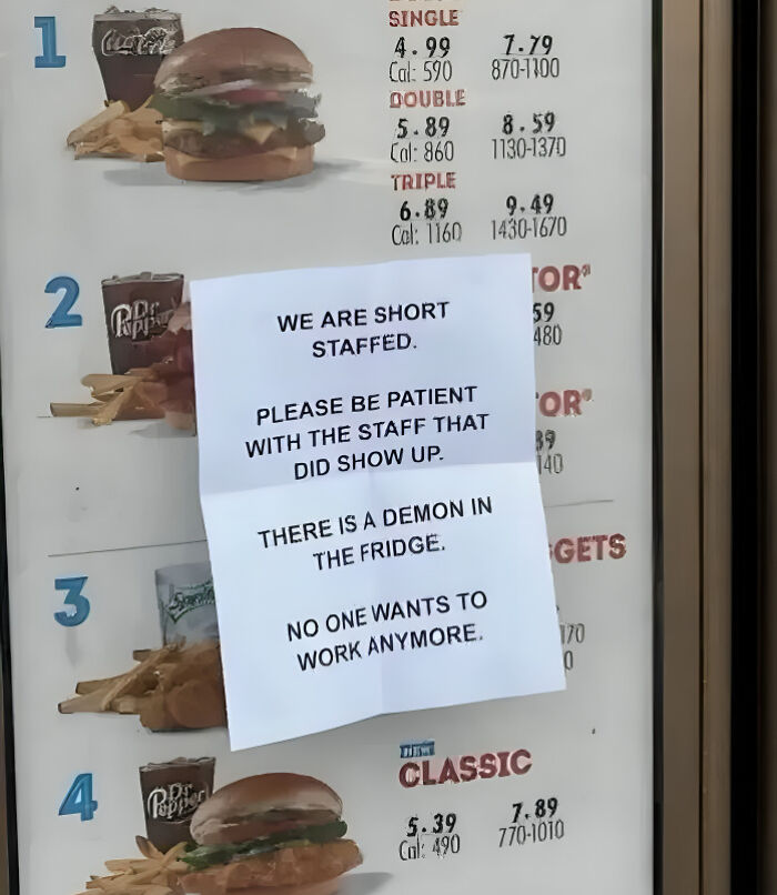 A fast food menu board with an unhinged note, indicating short staff and a 'demon in the fridge.'