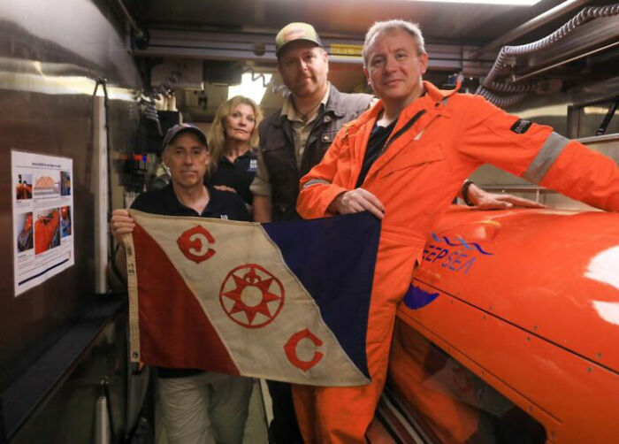 Researchers with a flag, celebrating the discovery of the Pan Am plane that crashed in 1952, found after 74 years. Researchers with a flag, celebrating the discovery of the Pan Am plane that crashed in 1952, found after 74 years.