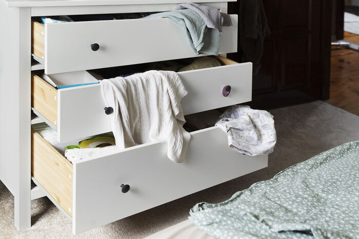 Open dresser drawers with clothes spilling out, reflecting gross stories about guests ignoring basic house etiquette.