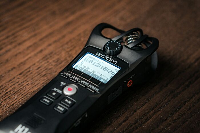 A Zoom H6 recorder on a wooden surface, symbolizing the collection of stories from divorced people about their marriage.