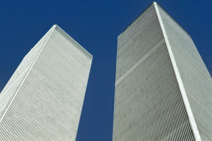 The majestic Twin Towers standing against a blue sky, symbolizing the 'We Need To Leave Now' moment from 9/11.