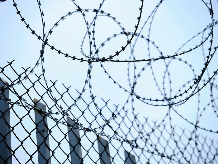 A close-up of a barbed wire fence against a light sky, illustrating the infuriating mansplaining examples.