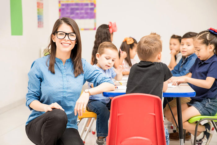 Teacher smiling with kids in a community class, after an entitled mom treated it like free daycare. Teacher smiling with kids in a community class, after an entitled mom treated it like free daycare.