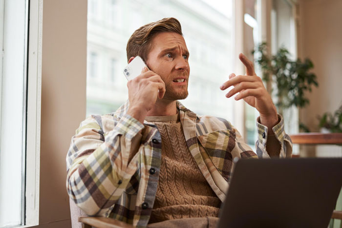 A man looking frustrated while on the phone, reflecting the conflict with an entitled mom. A man looking frustrated while on the phone, reflecting the conflict with an entitled mom.