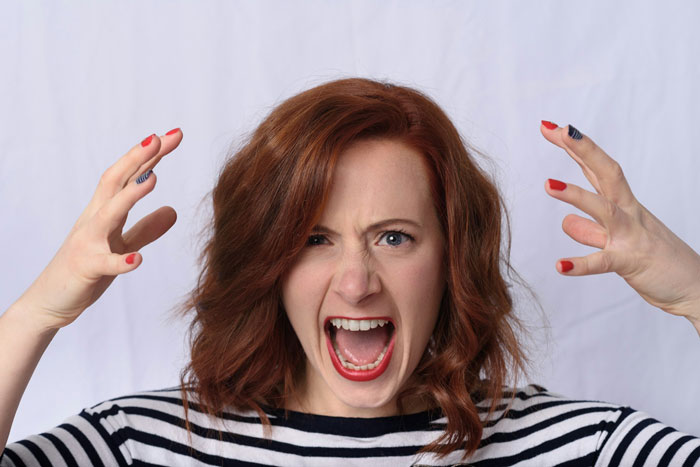 A red-haired woman screaming in frustration, embodying the entitled in-law fuming from the great-grandma's will. A red-haired woman screaming in frustration, embodying the entitled in-law fuming from the great-grandma's will.