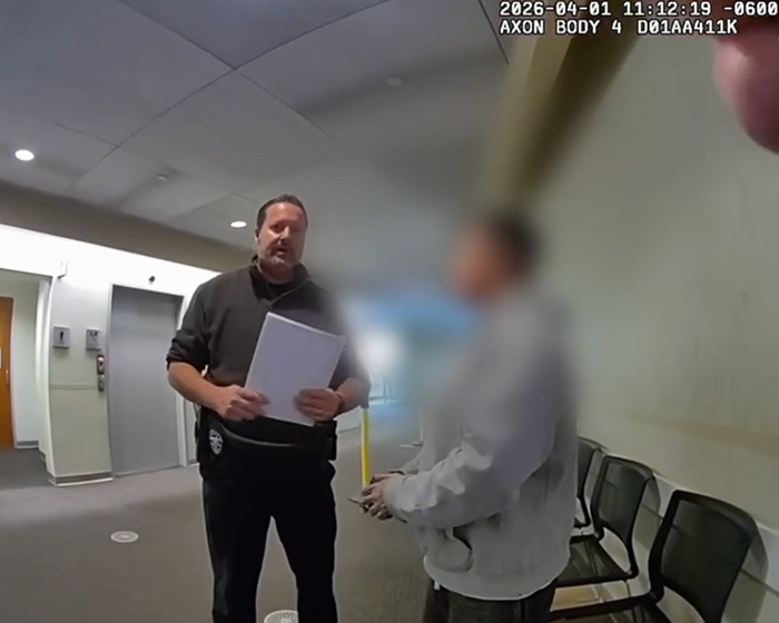 A blurred body camera footage shows a police officer speaking to a pixelated person in a hallway during a stupid arrest.