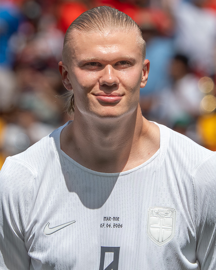 Erling Haaland smiling in a white Norway jersey, sparking memes about his viral raccoon arrival. Erling Haaland smiling in a white Norway jersey, sparking memes about his viral raccoon arrival.