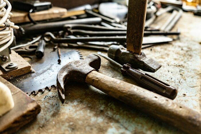 A close-up of various old tools, including hammers and saws, representing everyday items.