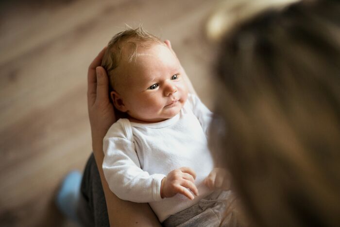 A person holding a newborn baby, highlighting everyday items and their many uses.