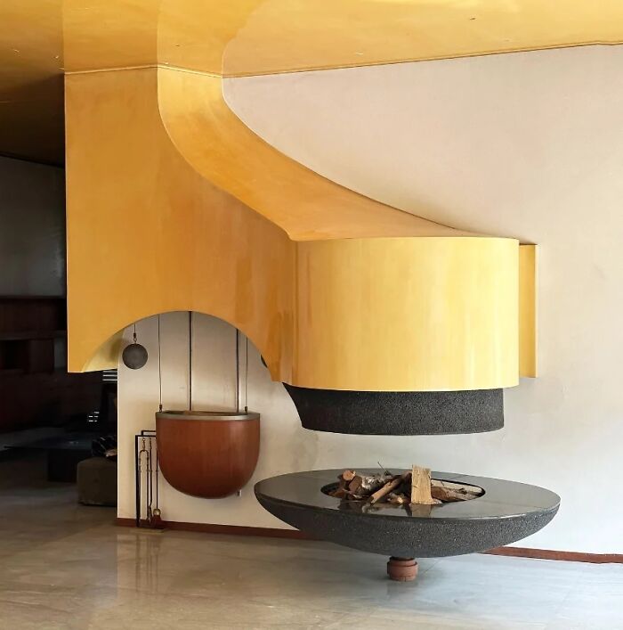 A remarkable historic interior design featuring a bold yellow fireplace and floating hearth.