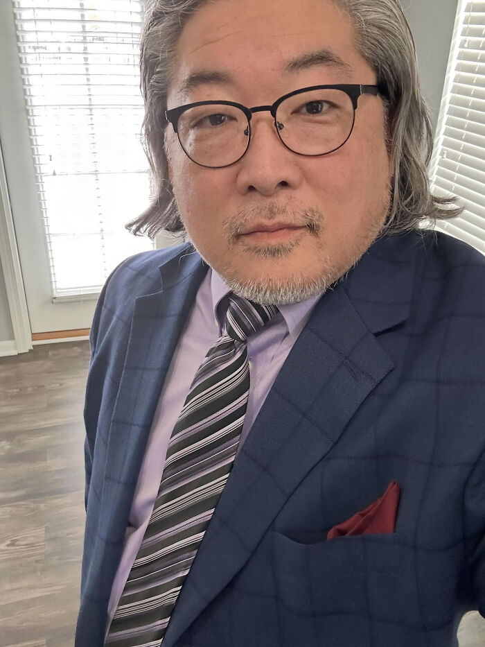 A man with grey hair and glasses wearing a suit and tie, whose looks don't match surprising facts.