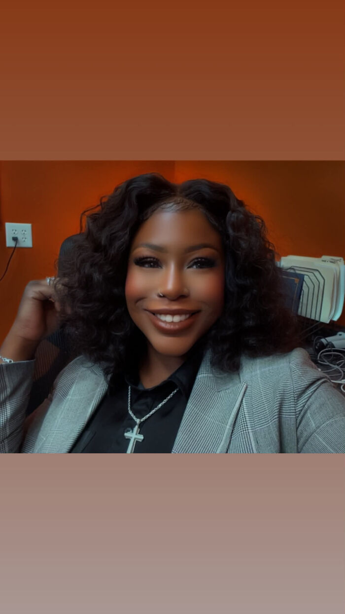 A woman in a blazer with curly hair and a cross necklace, revealing surprising facts that dont match peoples looks.
